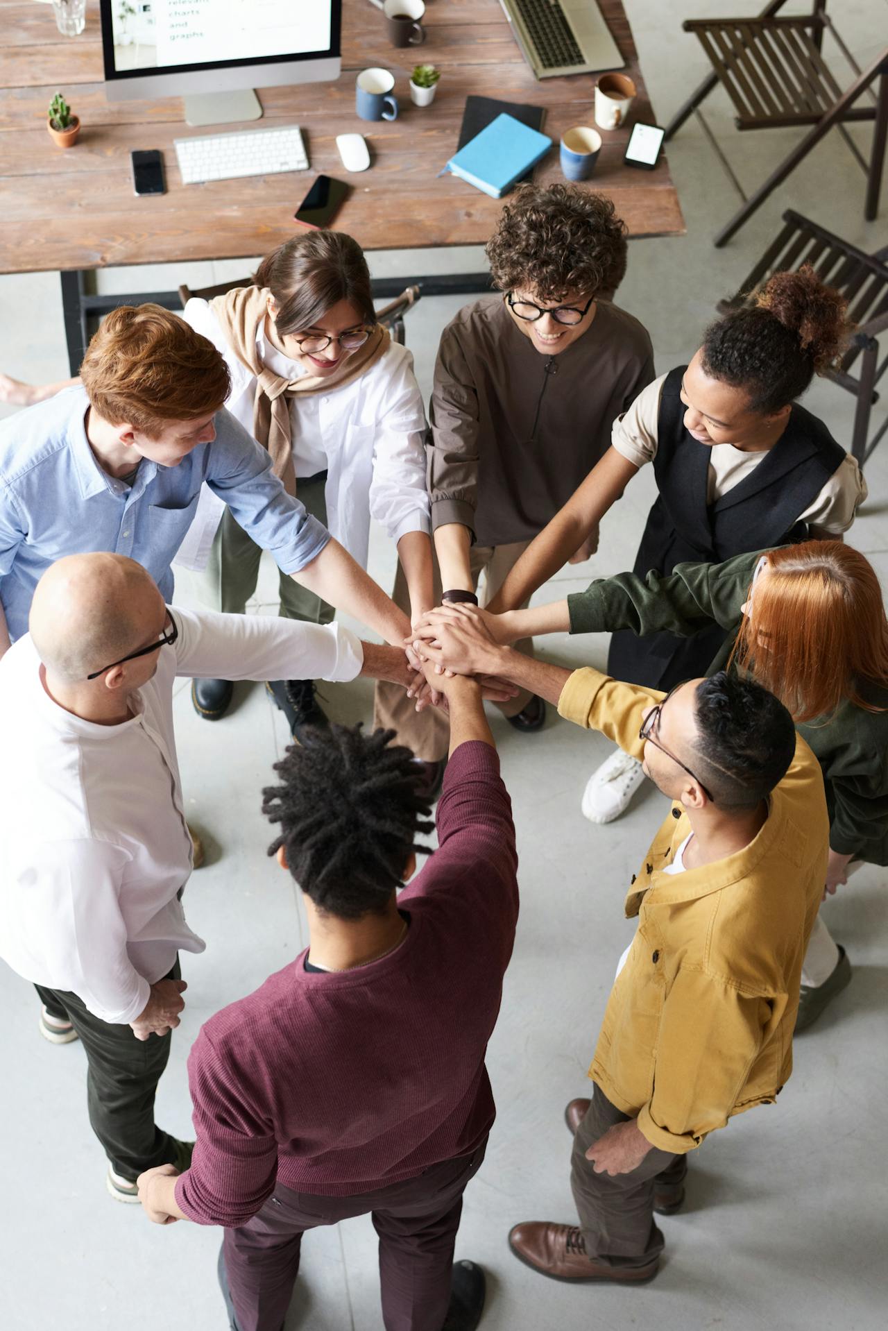 Students gathered round with hands forward to the center of the circle