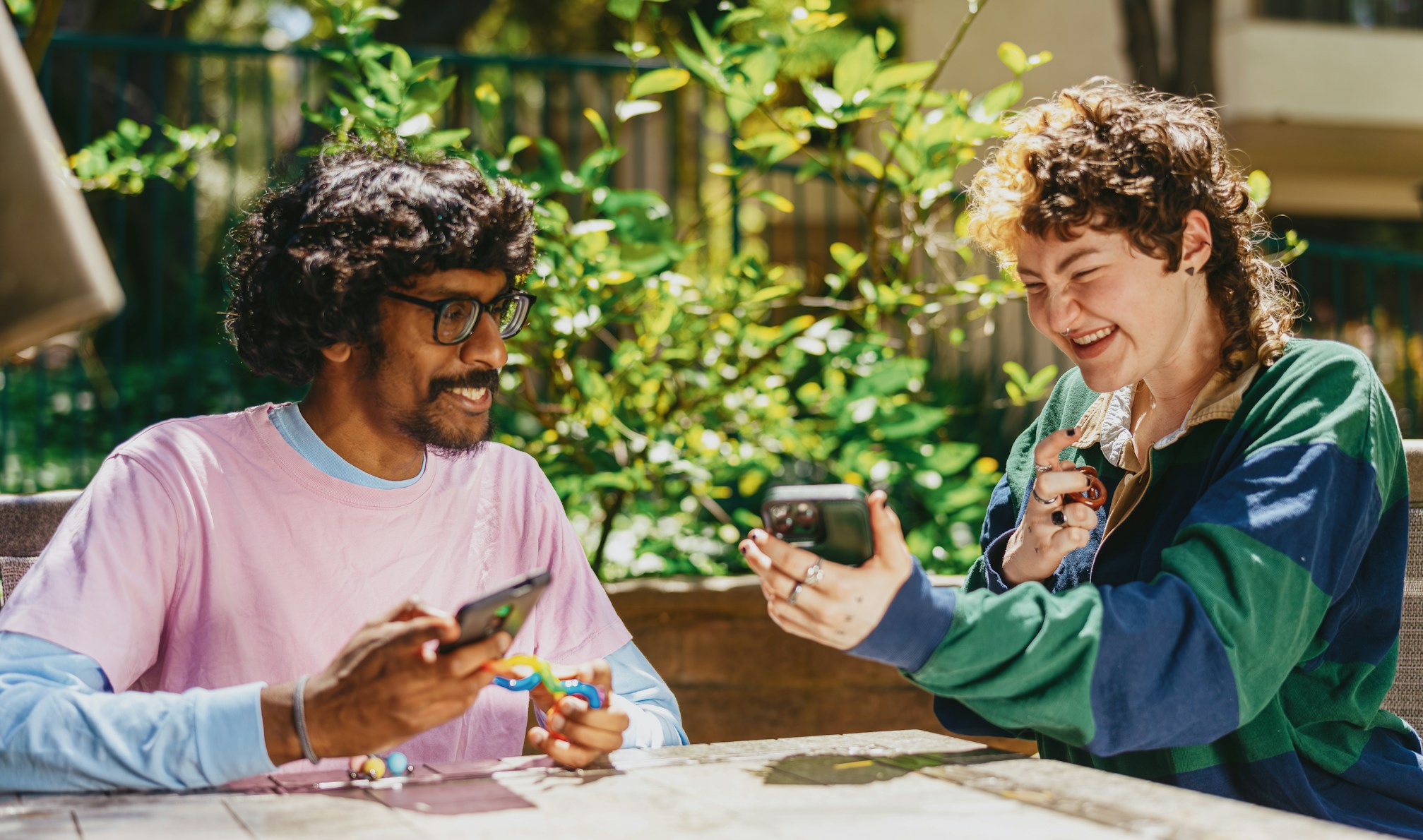 student smiling holding a phone to show environment