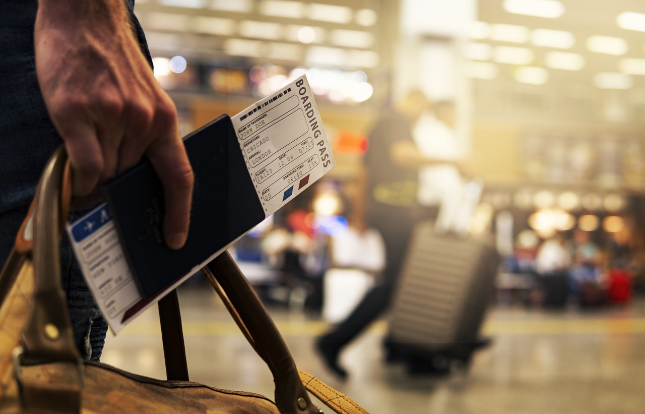 male handing holding a flight ticket in the airport